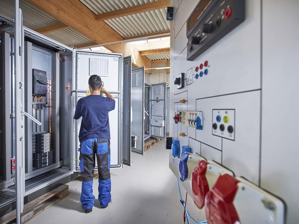 technicien en cours d'intervention sur une maintenance électrique industriel